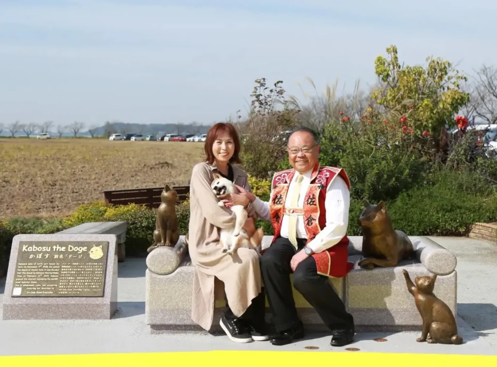 Atsuko and the Mayor of Sakura pose with Kabuso and her statue after the unveiling ceremony. The original couch was sold to someone at Twitter headquarters