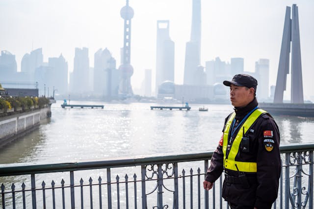 A Policeman Standing On A Chinese Bridge.